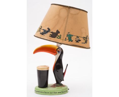 A Carlton Ware Guinness Toucan lamp: with shade painted in colours with advertising slogan to base, 41cm high (restored)