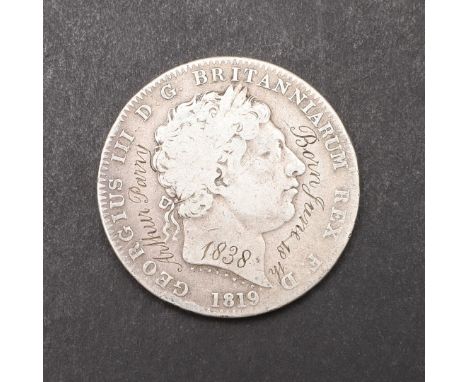 A GEORGE III CROWN WITH BIRTHDAY GRAFFITI FROM 1838. A George III Crown, laureate bust r. above date 1819, Reverse with St Ge