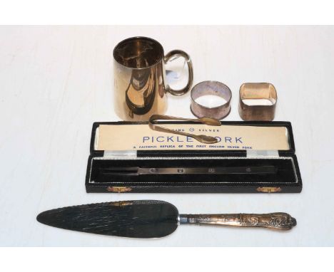 Small silver tankard, silver pickle fork, two silver napkin rings and silver handled cake slice.