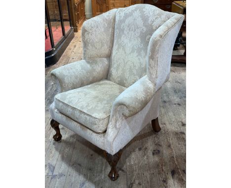 Wing armchair on ball and claw legs in light classical fabric.