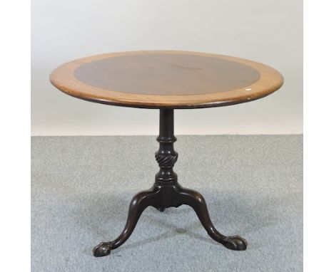 A 19th century mahogany and oak circular occasional table, with a hinged top, on a tripod base, 94cm