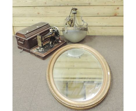 An oval gilt framed wall mirror, 85 x 60cm, together with a gilt metal hanging lantern with a glass shade, and a sewing machi