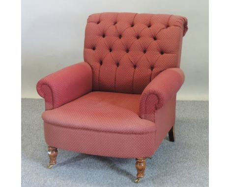 A red upholstered button back armchair, on turned legs
