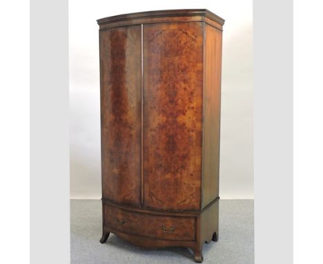 An early 20th century burr walnut bow front double wardrobe, on swept bracket feet, 97cm