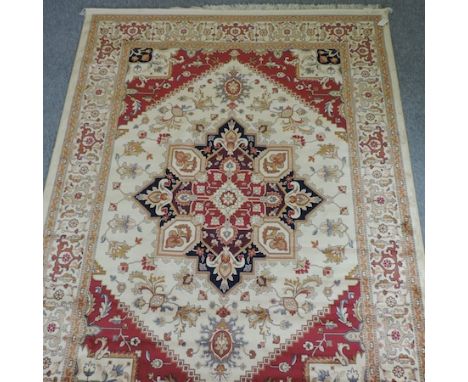 A Heriz carpet, with a central medallion and geometric designs, on a cream ground, 280 x 200cm