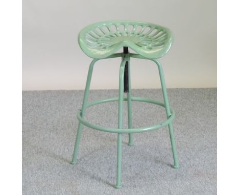 A green painted metal tractor seat bar stool