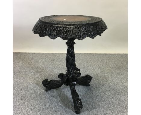 A 19th century Burmese heavily carved hardwood occasional table, on a tripod base, 64cm