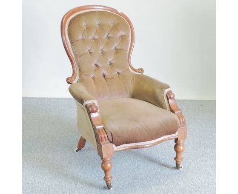 A Victorian carved walnut and brown upholstered button back armchair 