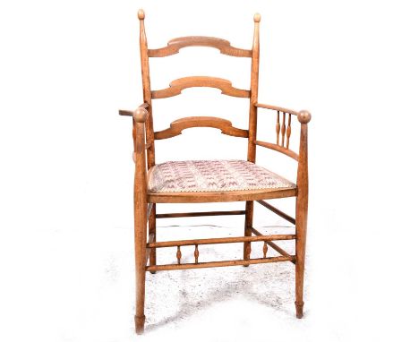 An Arts &amp; Crafts style stained beechwood ladder-back dining chair, three wavy rails, spindled arms, needlework seat, widt