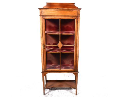 An Edwardian inlaid mahogany china cabinet, plain frieze, four panelled glazed door enclosing shelves, tapering legs, incurve