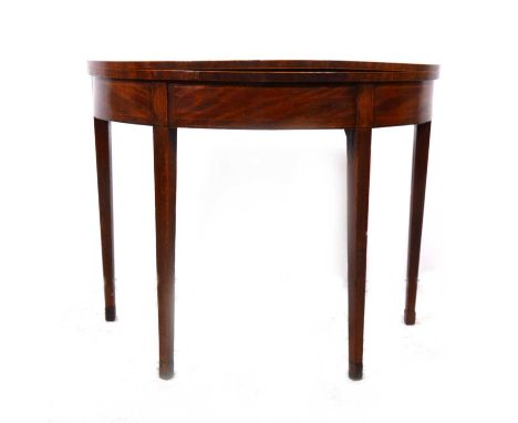 A George III mahogany demilune card table, foldover top with calamander banding enclosing a baize-lined interior, square tape