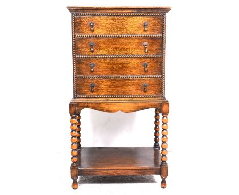 An oak and stained beechwood music cabinet, four flat front drawers, the stand with turned uprights and single shelf, width 5