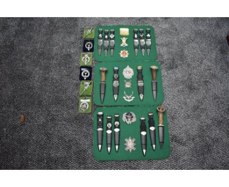 A collection of Scottish Highlanders Sgian Dubh (black dagger), 16 in total on 3 boards along with 13 Scottish Badges