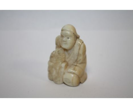 A VINTAGE NETSUKE IN THE FORM OF A KNEELING MAN 