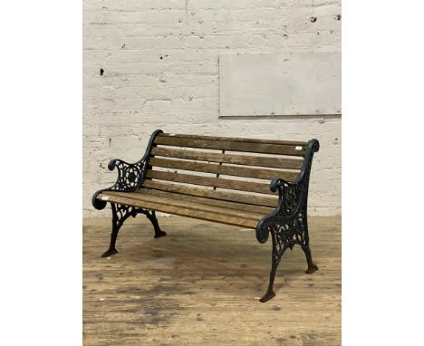 A cast metal and slatted teak three seat garden bench. L126cm.&nbsp;