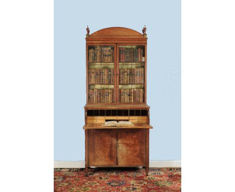 A George III satinwood and purple heart banded secretaire bookcase, circa 1790, the arched pediment corned by patera painted 