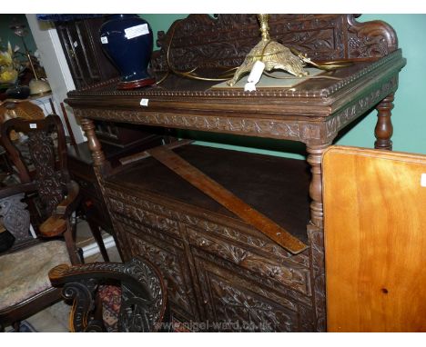 A most unusual Mahogany Sideboard/Dumb Waiter having profuse carved decoration with trailing Ivy and floral stems, raised on 