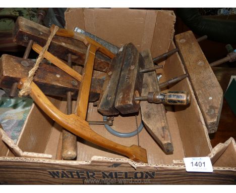 Three old style wooden furniture clamps, an old twist-string tensioned bow-saw, two fret-saw frames one with blade, a setting