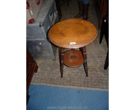 An Arts &amp; Crafts Mahogany Occasional Table having a circular top and lower shelf and standing on turned legs. 16 1/2" dia