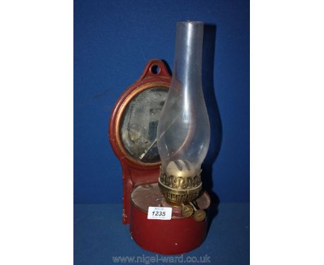 A wall-hanging paraffin Lamp, burgundy coloured with mirrored back.
