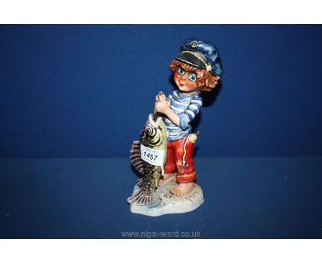 A large Goebel figure of a boy and fish, 9" tall, with a Michel T signature.