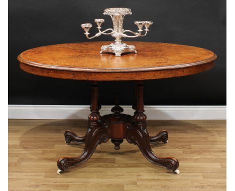 A Victorian walnut and marquetry centre table, oval quarter-veneered tilting top inlaid with bell husks and whiplash stems, q