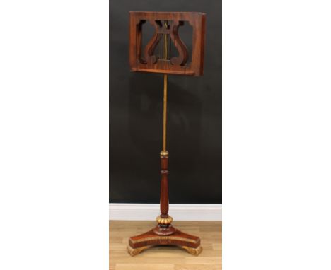 A Regency parcel-gilt rosewood and walnut duet music stand, each adjustable plateau centred by a lyre, turned pillar, fluted 