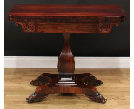 A William IV rosewood card table, rounded rectangular folding top above a deep frieze, panelled baluster pillar, scroll feet,