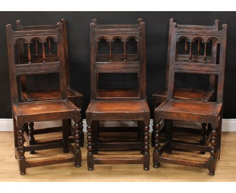 A set of six oak Charles II style 'Derbyshire' side chairs, each with an architectural back, boarded seat, bobbin-and-reel tu