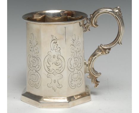 A Victorian Gothic Revival silver octagonal mug, engraved with leafy C-scrolls and cartouches, foliate double-scroll handle, 
