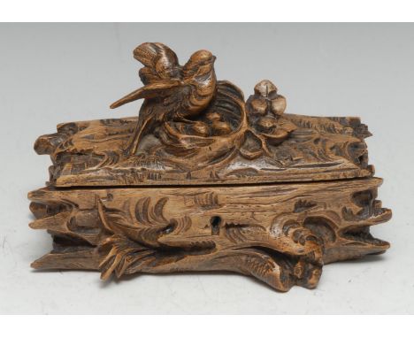 A Black Forest jewel casket, carved as a bird with a nest of eggs, upon a fallen trunk, hinged cover, damson velvet lined int