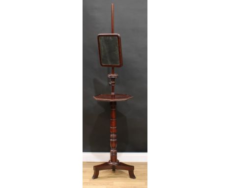 An early Victorian mahogany shaving stand, rounded rectangular mirror above an octagonal plateau, turned pillar, triform base