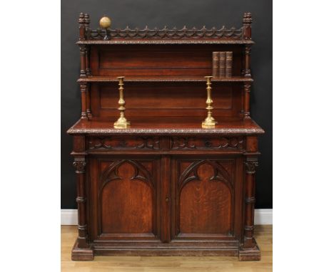 A Gothic Revival oak side cabinet or chiffonier, the superstructure with a pierced three-quarter gallery moulded with swags, 