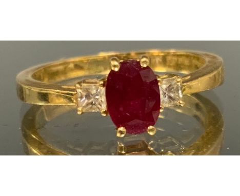 A ruby and diamond trilogy ring, central oval red ruby approx 0.50ct, flanked by a princess cut diamond either side, total es