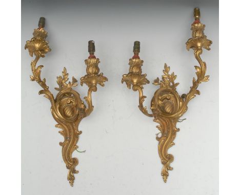 A pair of Louis XV Revival gilt metal two-light wall sconces, cast throughout with scrolling acanthus, 52cm long, early 20th 