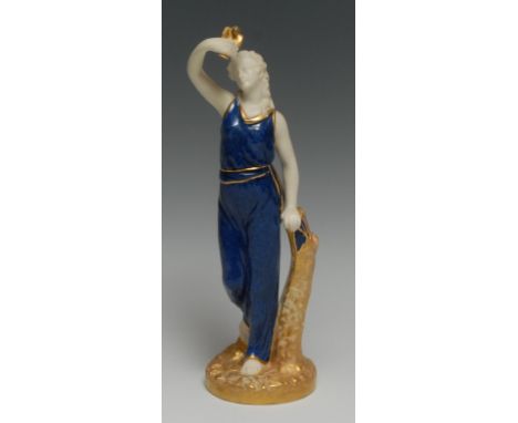 A Royal Worcester figure, Liberty, she stands holding a dove aloft, wearing flowing blue robes, tied with a gilt sash, picked