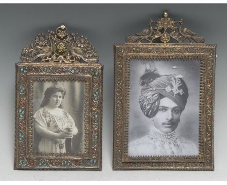 An Indian silver rectangular photograph frame, the shaped cresting pierced and chased with a pair of peacocks centred by an e