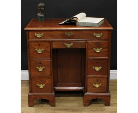 A George III mahogany kneehole desk, rectangular top with moulded edge above a long cockbeaded frieze drawer, further drawers