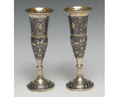 A pair of Russian silver-gilt and niello trumpet shaped pedestal goblets, decorated with leafy scrolls, knopped stems, domed 