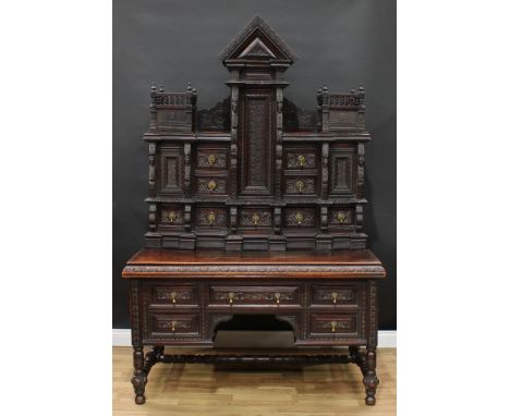 A late Victorian Renaissance Revival oak cabinet on stand, architectural upper stage with an arrangement of doors and drawers