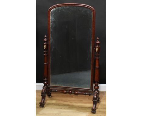 A Victorian mahogany cheval mirror, arched rectangular plate, spire finial capped turned supports applied with gilt brass tap