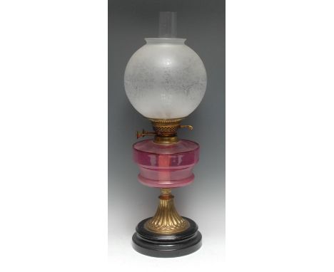 An early 20th century cranberry glass and brass table oil lamp, globular etched glass shade, Duplex-type adjustable double bu