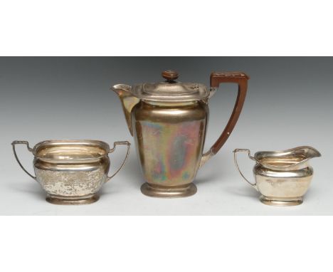 A George V silver part tea service, comprising hot water pot, milk jug and sugar basin, acanthus-capped angular scroll handle
