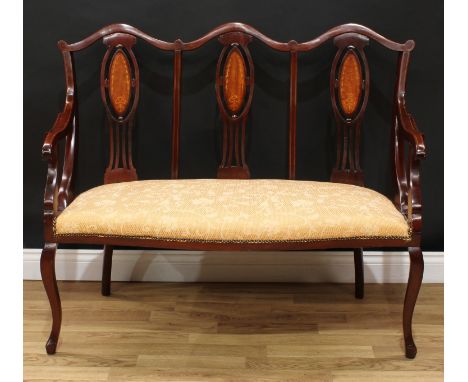 An Edwardian Hepplewhite design mahogany triple-chair-back sofa, each pierced splat inlaid with a ribbon and bell husks, stuf