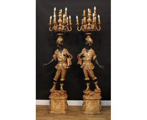 A pair of substantial Venetian softwood and composition blackamoor floor-standing torchère lamps, each carved as a Nubian att