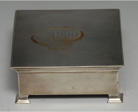 A George V silver square cigarette box, hinged engine turned cover, bracket feet, Birmingham 1928 