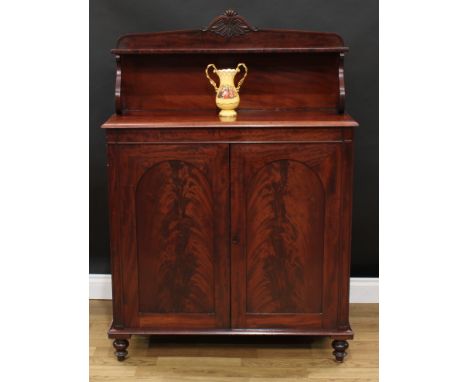A Victoria mahogany chiffonier, the superstructure crested by carved and applied scrolls and corolla above a small shelf, scr