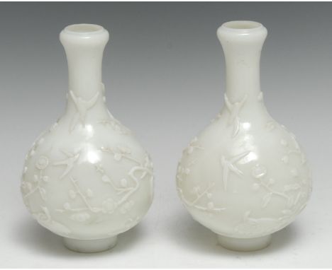 A pair of Chinese Pekin glass ovoid vases, in relief with blossoming prunus, 17cm high, seal marks, 19th century 