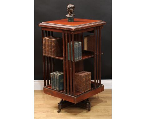 A Victorian walnut revolving bookcase, moulded square top above two rows of slatted shelves, quadform base, ceramic casters, 