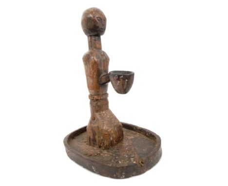 Unusual African tribal carved wooden lamp, centred by stylised figural post and central receptacle, on ovoid dished base, 46c